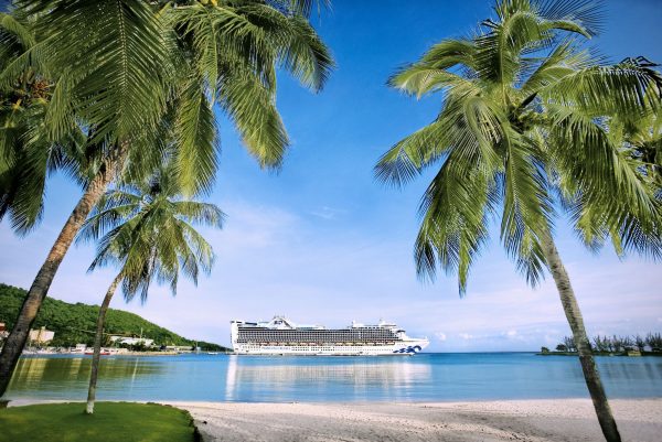 Caribbean Princess Cruise Ship among palm trees and a beach.